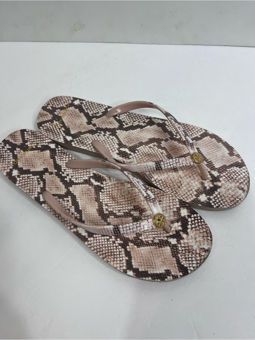 Tory Burch thin flip flop sandals in snakeskin print.